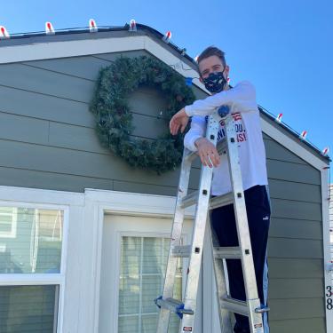 Two Men and a Truck hanging wreaths on Veterans Community Project Tiny Houses