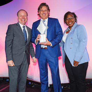 Photo of Joe Reardon, Charlie Tetrick with the Mr. K Award, and Dr. DeAngela Burns-Wallace on stage at the 2024 Small Business Celebration